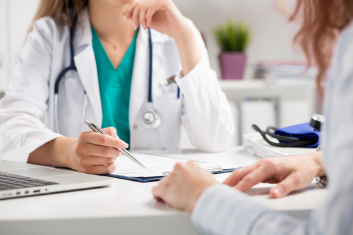 A doctor and patient discussing something  Description automatically generated